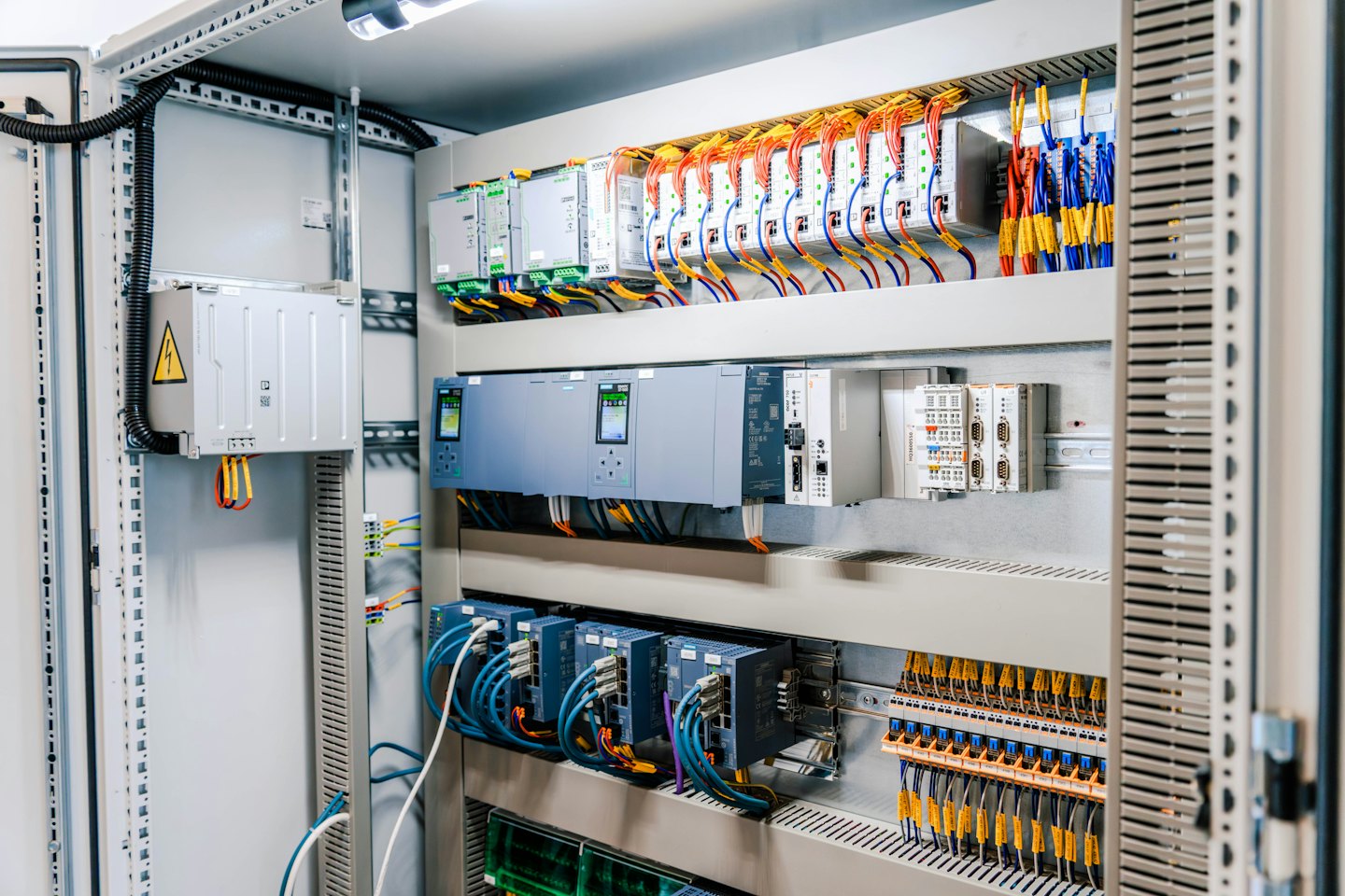 Electrical control cabinet with organized modules and colorful wires.